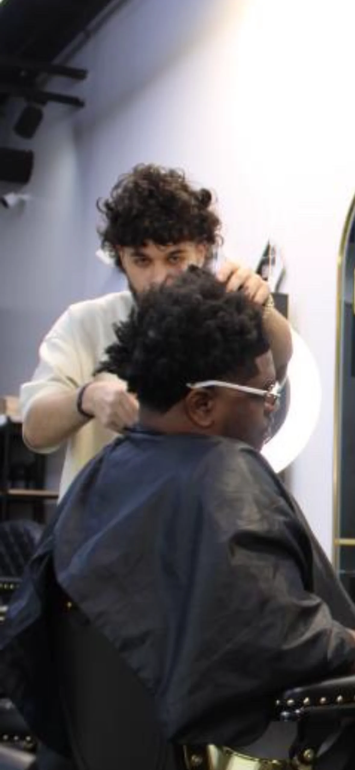 Aram cutting a client’s hair inside SB Barbershop