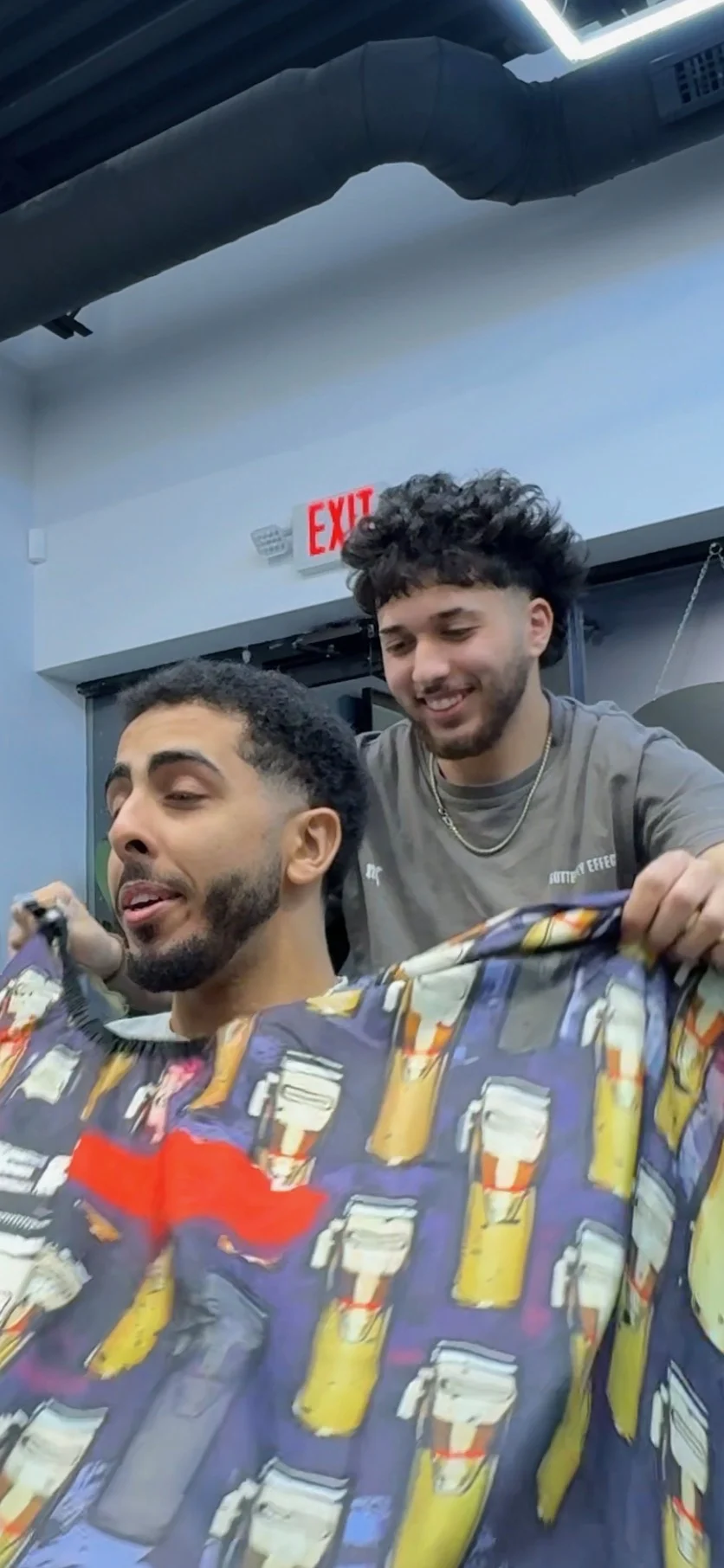 Aram presenting a client’s finished haircut inside SB Barbershop